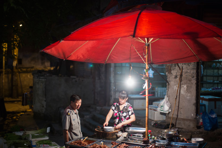 A woman sells chicken and duck pieces at a street stall at the bottom of Shibati.