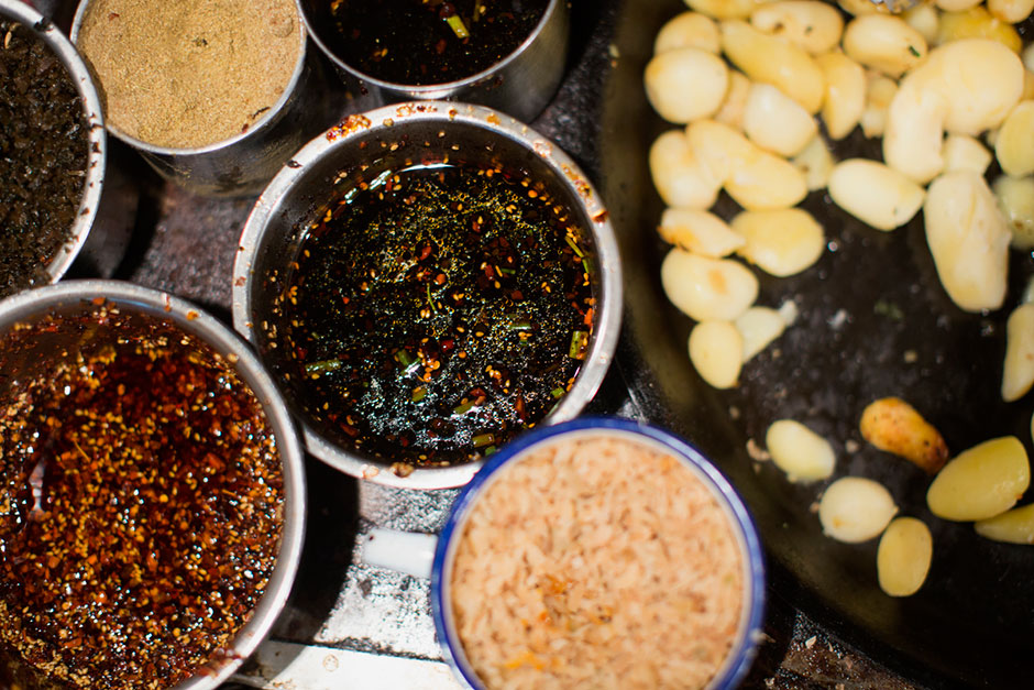 A top-down view of Xie Guangrong’s food cart shows the <em>tudou ni</em> (smashed fried potatoes mixed with spices) at her food stand outside the B District Middle Gate of Chongqing University. Here, a large helping of <em>tudou ni</em> costs 3 RMB or about U.S. 50¢.
