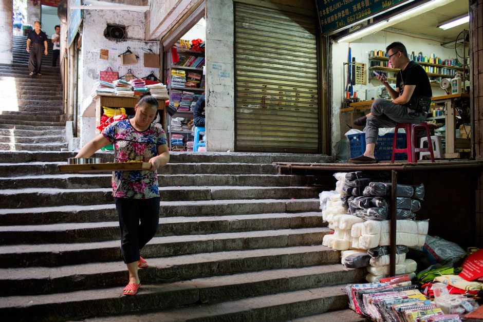 A restaurant worker takes lunch to a stall in a market off Shaanxi Road.