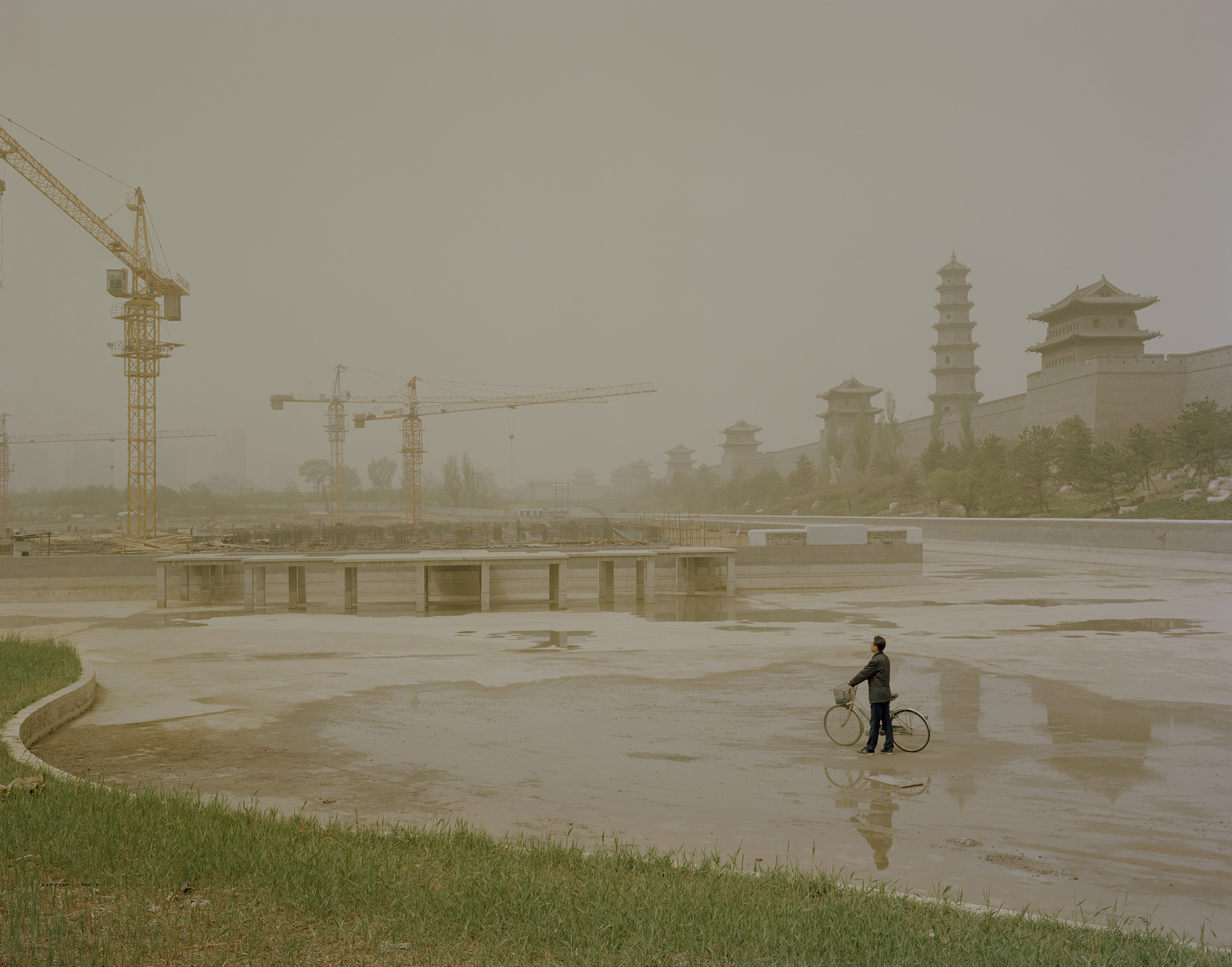 Tower cranes in operation at a construction site near the wall of Datong’s “ancient city.” In 2013, Geng was suddenly promoted and became the mayor of Taiyuan, the capital of Shanxi. He left behind a mountain of government debt and unfinished construction. Still, he was praised highly by locals for being a politician who took action.