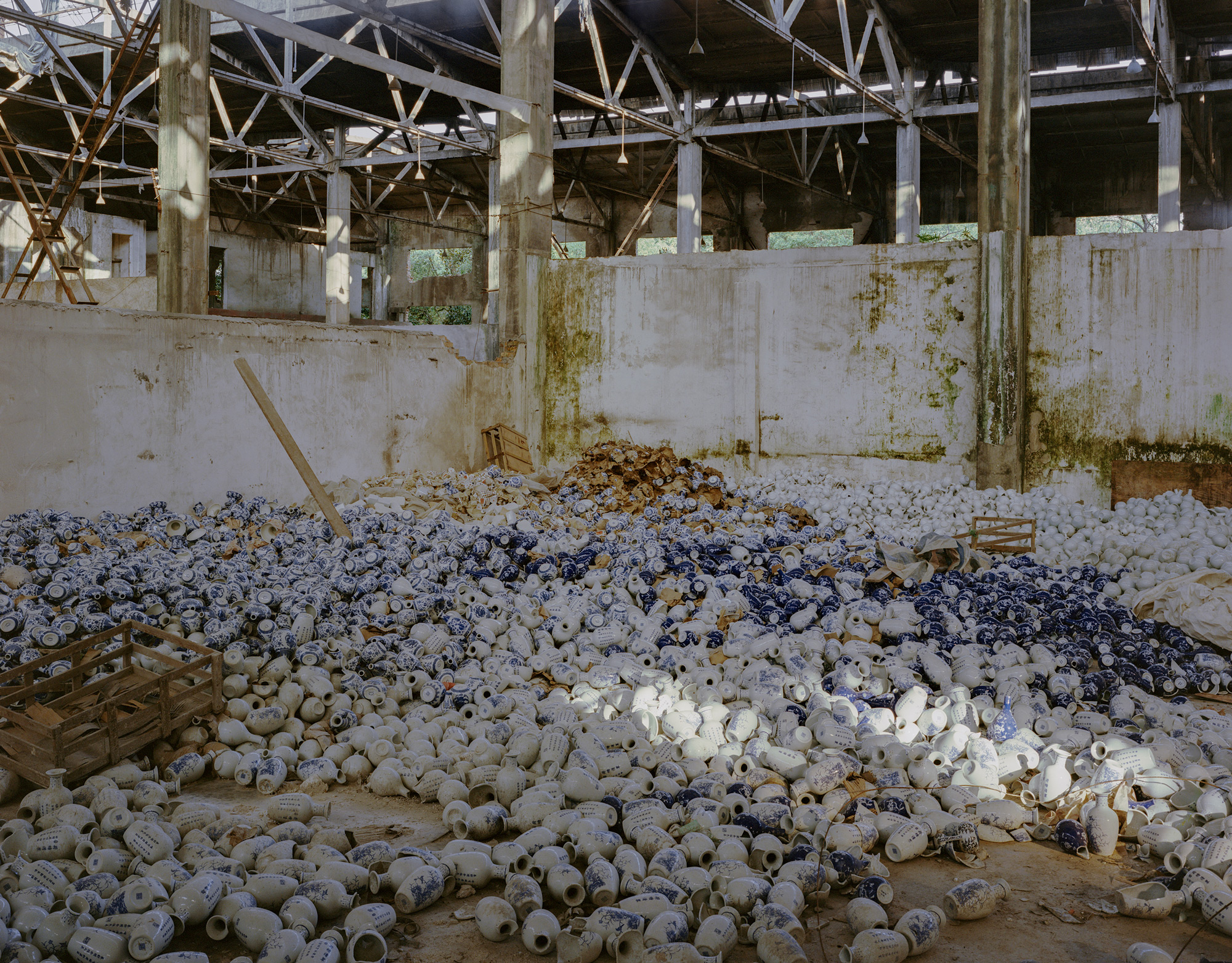 Bottles lay strewn across the floor of a porcelain factory in Jingdezhen city, Jiangxi province, July 2017. Jingdezhen is the historic center of Chinese porcelain production, famous for its high-quality kaolin reserves. However, as kaolin reserves have been depleted, hundreds of mining and production companies have been shuttered over the past two decades.  