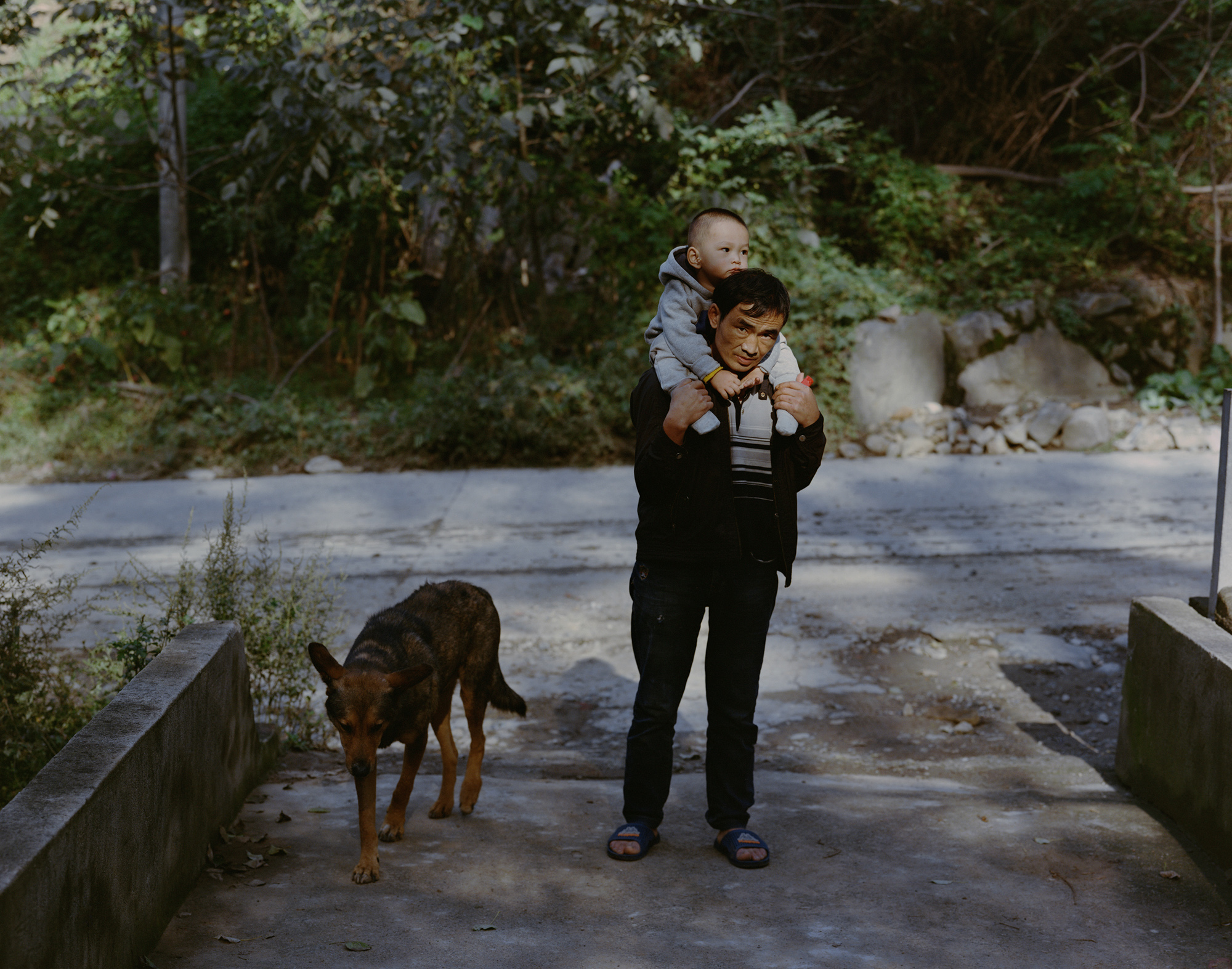 Dai Guanping, a 47-year-old miner, carries his son on shoulders, at the Five Kilometer Mine, in Tongguan. He said he has less and less work because of the exhaustion of local gold deposits.