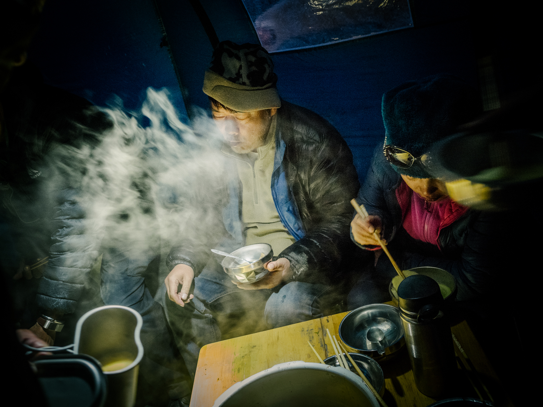 The team eats dinner together. Yang and his brother, Yang Hongbing, cooked most of the meals on the expedition.