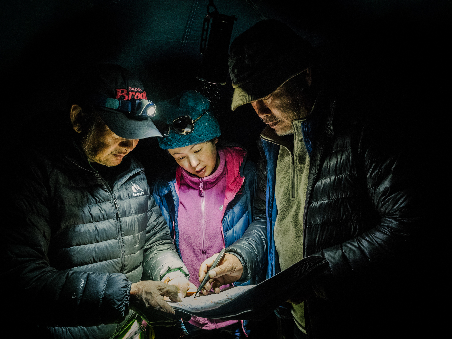 Yang, his wife, Wang Qian, and his friend and drone operator they affectionately call Captain Lu plan the next day’s travels using a topographical map.