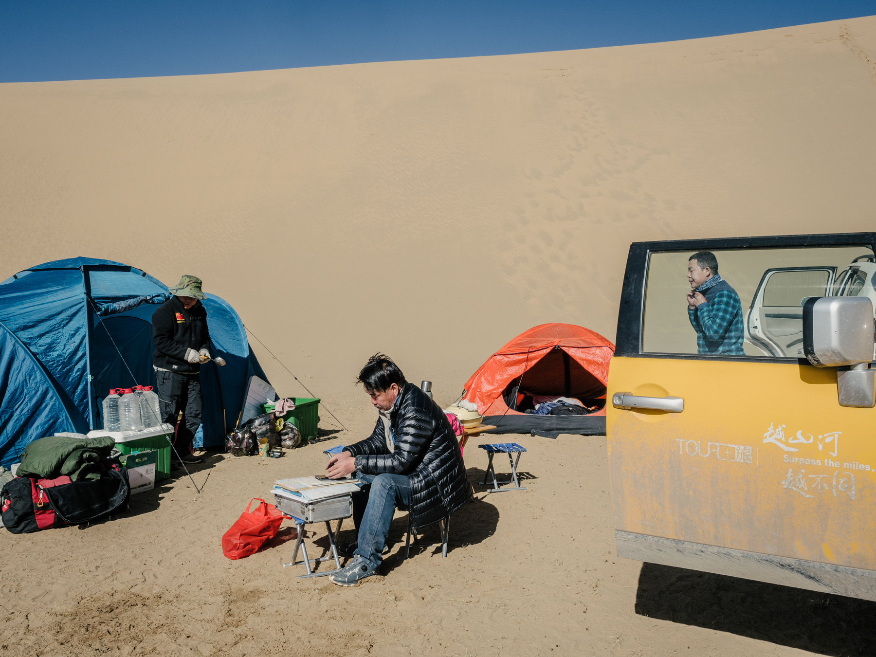 Yang looks at his phone, which displays maps and satellite images of the region near Rigecuochama, a lake off of the Yellow River, in Madoi county. Headwaters of the Yellow River originate in Madoi. The county is severely affected by desertification, with 35% of its land now desert.