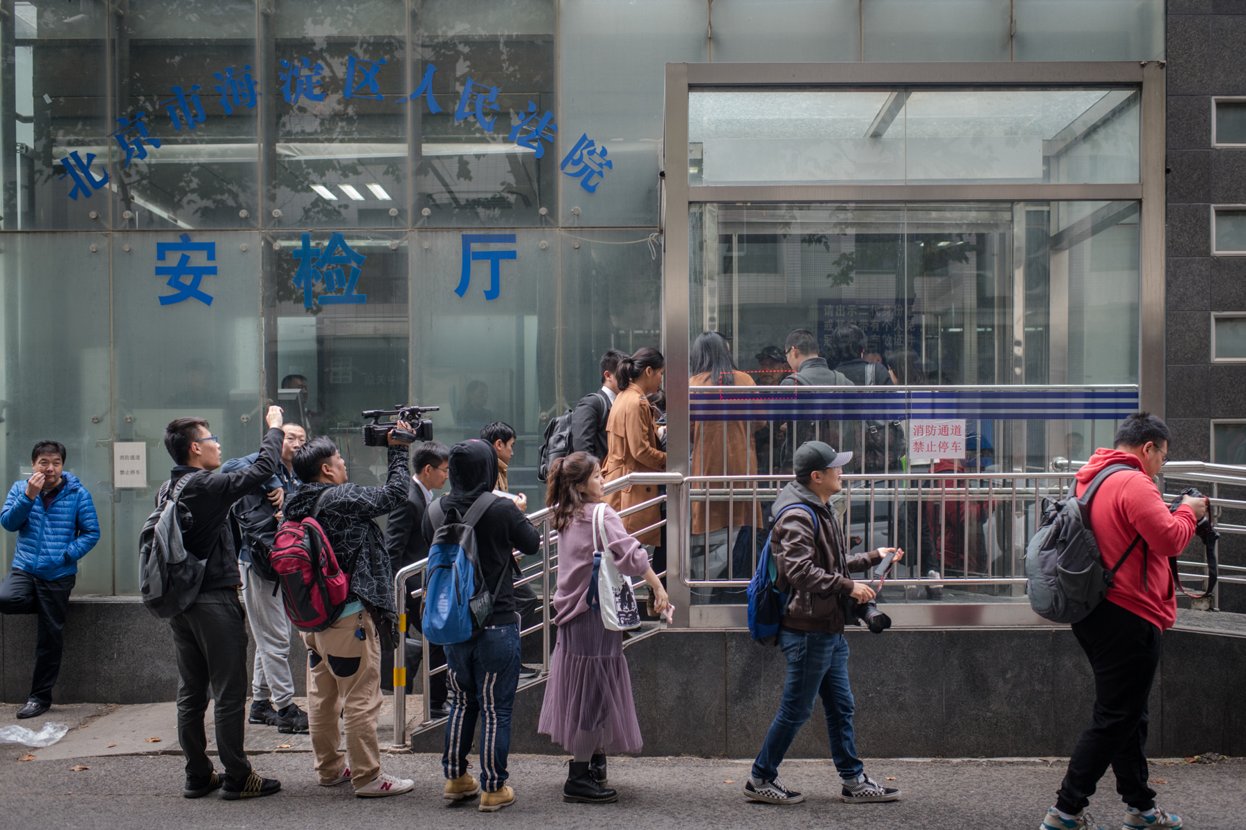 Press wait outside the court during the pretrial evidence exchange, October 25. The hearing took more than two hours. Zhu did not attend.
